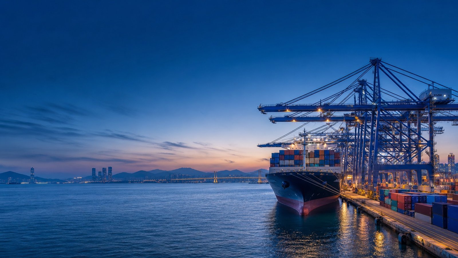 Container vessel and quay cranes at a South Korean port during blue hour